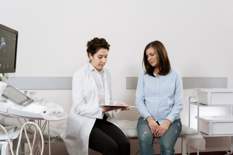 A pregnant woman consulting with a gynecologist in a medical facility.